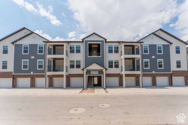 View of property with a balcony and a garage