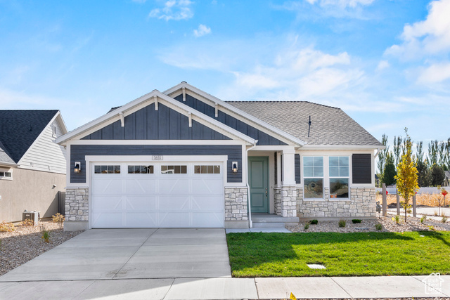 Craftsman-style home with a front lawn and a garage