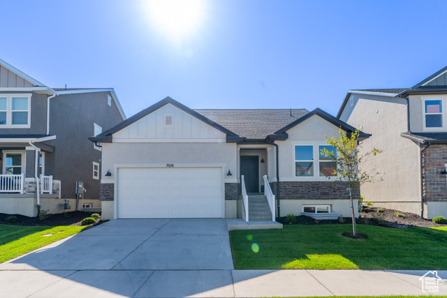 View of front of house with a garage and a front lawn