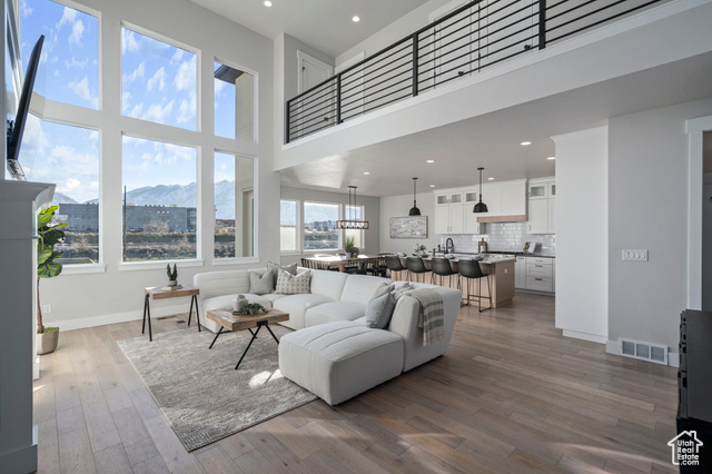 Living room featuring a mountain view, a towering ceiling, and hardwood / wood-style floors