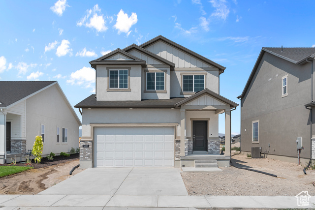 Craftsman-style house featuring cooling unit and a garage