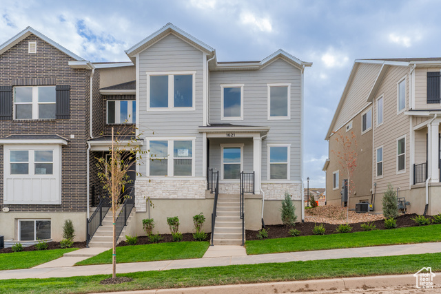 Townhome / multi-family property featuring a front yard and central air condition unit