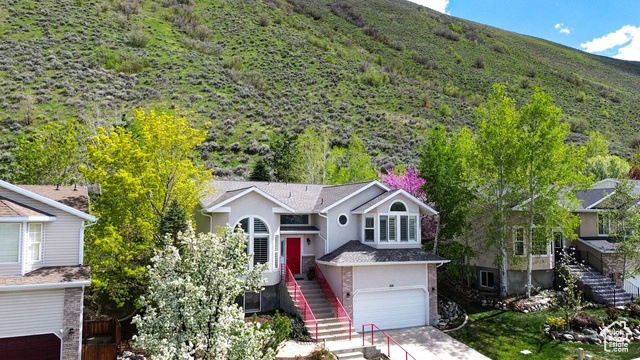 Sunny Draper home with a mountain backdrop - a rare and covetable feature right out the back door! And located afew short blocks from the world-renowned paragliding/hang-gliding destination, Flight Park State Recreation Area. Attentively cared-for 5 bedroom, 3 bath (4 bedrooms, 2 baths on same level!) including a large primary suite with a  view of valley lights. Two of the main-floor bedrooms also have beautiful nature views. This home feels airy and expansive with good living and plentiful storage spaces. Updated kitchen with granite countertops, newer LG appliances, walk-in pantry, and corner window over the sink. New in the last three years: central A/C, water heater, roof and gutters, heat tape, carpeting, Karastan Luxecraft LVP flooring in the living room, a xeriscaped parking strip with two new flowering plum trees, and a 4-person Bullfrog hot tub. And so many other desirable features: a variety of sizable windows, arched, clerestory, and bay; custom plantation shutters and wood blinds; vaulted ceilings; lower level has above-grade light with boulder egress window wells, and two unfinished rooms for gear or a multitude of possible uses! All this and an unbeatable location with access to Bonneville Shoreline Trail from the backyard. Views of Mount Majestic, and of sunrises that turn the hill pink. Landscape lighting, deck, smart-scaped front and back includes spruce, quakies, Bradford pear, purple rock cress, Evergreen candytuft, lavender, and forsythia, plus rockscapes, flagstone paths and patios; custom railings and mailbox by local artist Rich Metal Arts. Quiet neighborhood on a low-traffic street. Ready to move in and enjoy right from the get go.