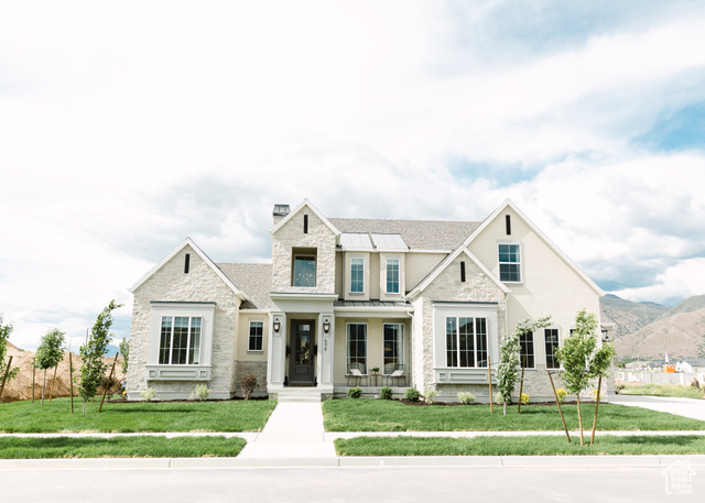 View of front of home featuring a front yard, a mountain view, and covered porch