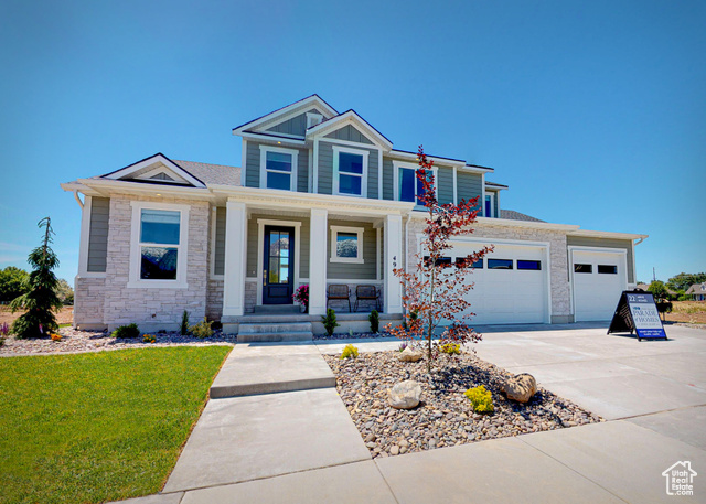 Craftsman inspired home with a garage and a porch