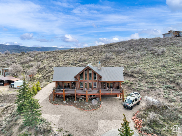 This stunning log mountain home offers incredible, breathtaking views of Mount Timpanogos and the entire Wasatch Back! The towering, vaulted tongue and groove ceilings, massive windows, the spacious, sprawling back deck and open great room concept, makes this mountain haven the perfect setup for ultimate entertaining or beautiful quiet sunset evenings! This rustic retreat features a main level luxurious master ensuite complete with gas burning stove, skylights, enormous jetted tub, walk-in closet and French doors that open out onto the deck. The open loft is used as a study, but could also function as additional sleeping quarters. Imagine working from home in this dreamy retreat! The downstairs offers the same unbelievable views with a cozy, comfortable family room area, full bathroom and two large bedrooms. Offered fully furnished, turnkey with kitchenware and linens! Gorgeous landscaped yard with paved driveway. Dual water heaters, brand new AC and Water Science filtration system. The craftsmanship and meticulous style of this cabin perfectly compliments a true mountain lifestyle! Surrounded by recreational activities at your fingertips including, boating on nearby lakes, world-class golf, phenomenal skiing, epic snowmobiling, hunting, hiking, access to Uinta National Forest, mountain biking, ATV-ing and more! Located only 5 minutes from Timber Lakes entrance. Only 55 minutes to the SLC airport and just minutes from all the wonderful amenities of the Heber Valley & Park City! YEAR ROUND access!