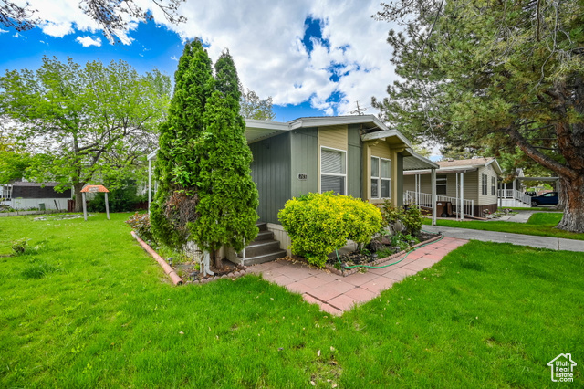 View of home's exterior featuring a carport and a lawn