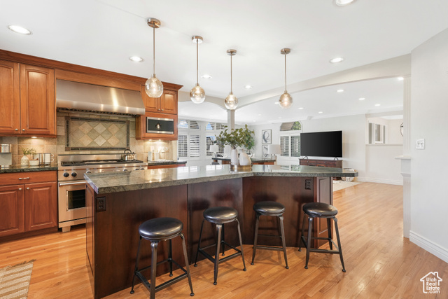 Kitchen with a wall chimney exhaust hood, and a kitchen island