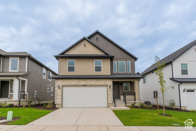 Craftsman-style home with a porch, a garage, central AC unit, and a front yard