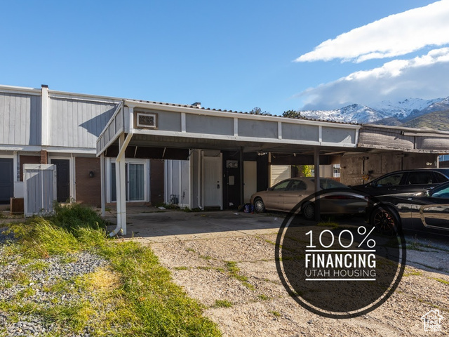 Back of property with a mountain view and a carport