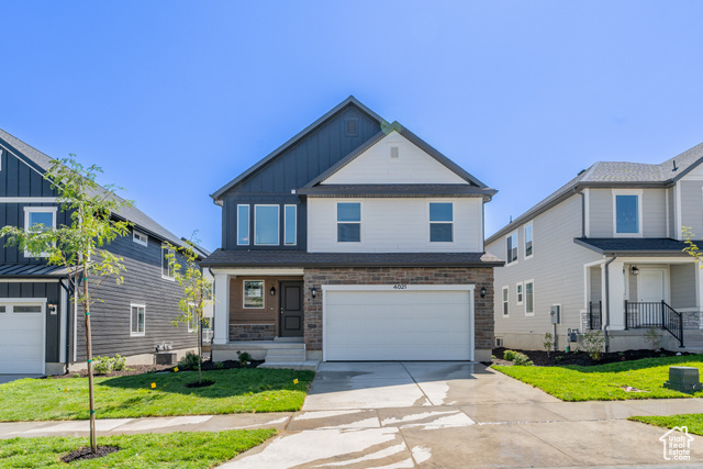 View of front facade featuring a garage and a front lawn