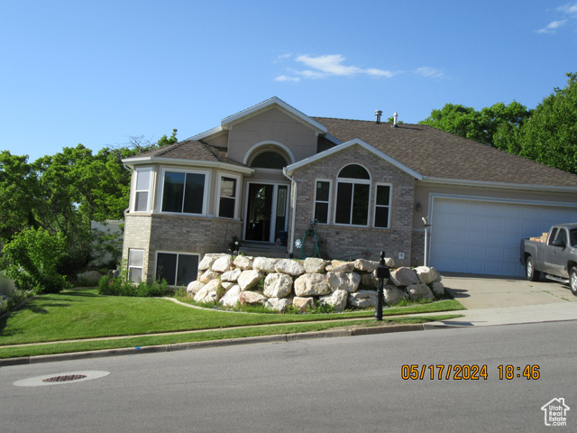 View of front of property with a front yard and a garage