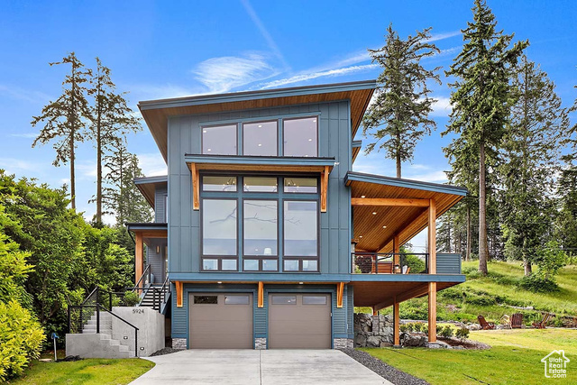 EXAMPLE Of Contemporary house featuring a garage and a front yard