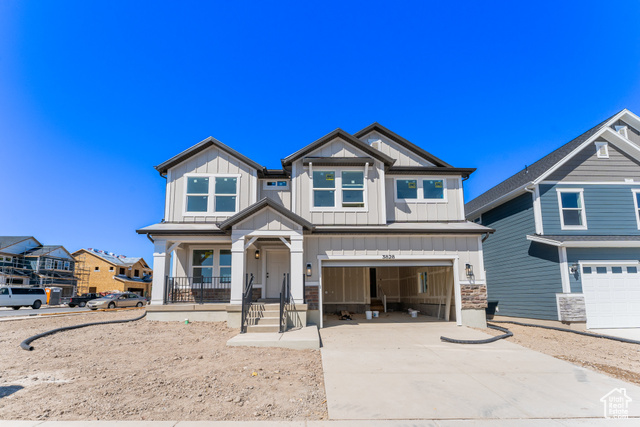 Craftsman house featuring covered porch and a garage