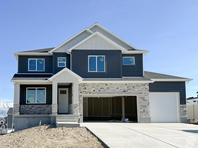 Craftsman-style home featuring covered porch and a garage