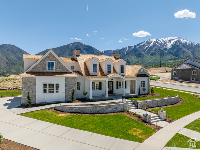 View of front of property with a front yard and a mountain view