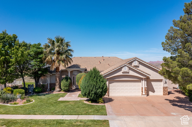 View of front of property with a garage and a front lawn