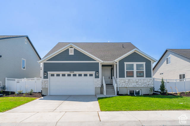 View of front of house featuring a garage and a front yard