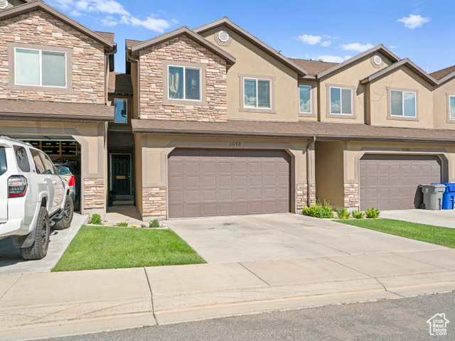 Townhome / multi-family property featuring a garage