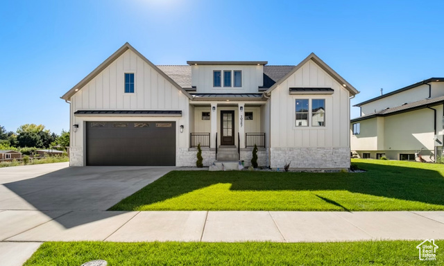 Modern inspired farmhouse featuring a tandem garage and a fully landscaped  yard