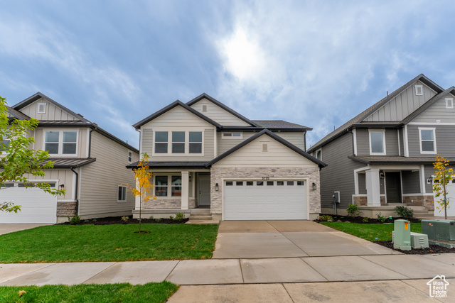 Craftsman inspired home featuring a front lawn and a garage