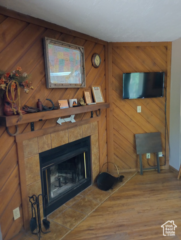 Living room with a tile fireplace and wood-type flooring