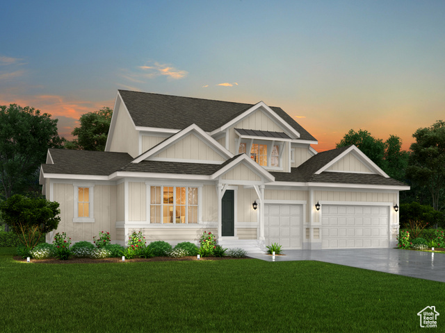 View of front of house featuring a garage and a yard