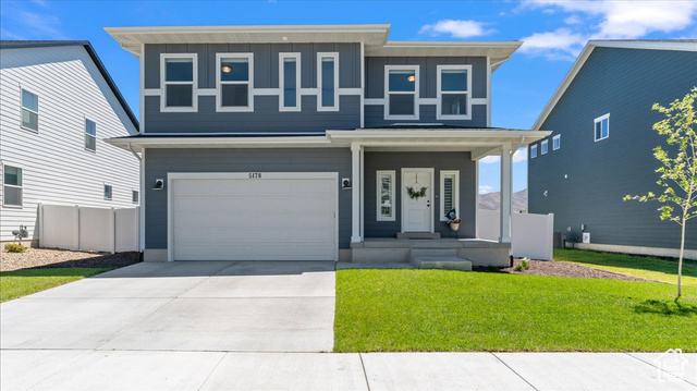 View of front of house with a garage and a front yard