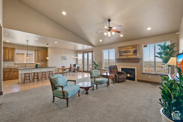 Living room featuring light colored carpet, vaulted ceiling, sink, and ceiling fan