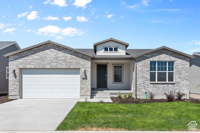 View of front of house with a garage and a front lawn