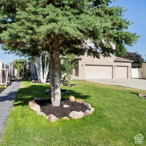 View of front of house with a garage and a front lawn