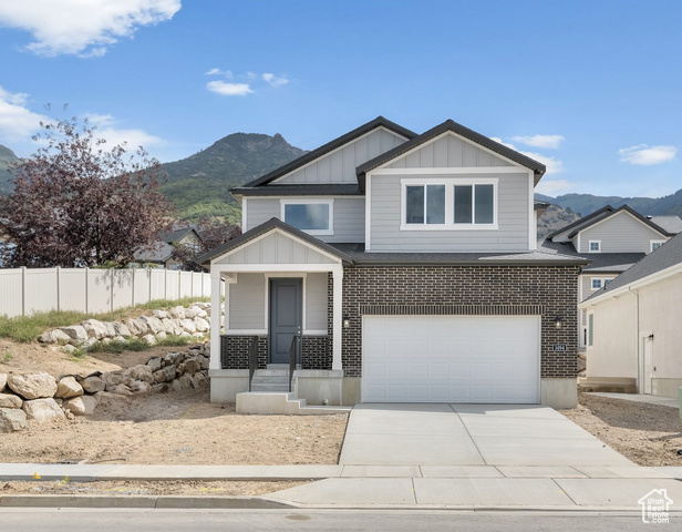 View of front facade with a garage and a mountain view