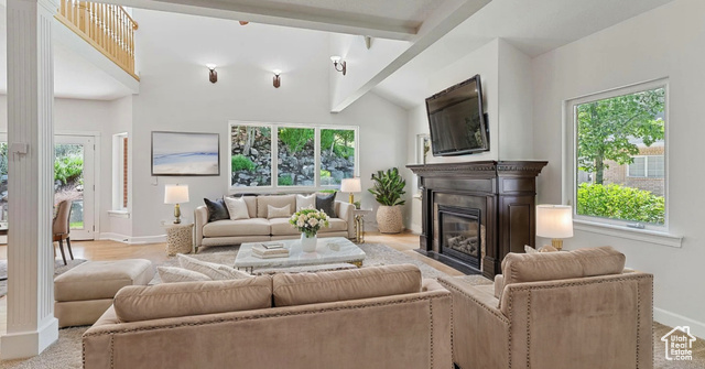 Living room featuring vaulted ceiling with beams and a healthy amount of sunlight