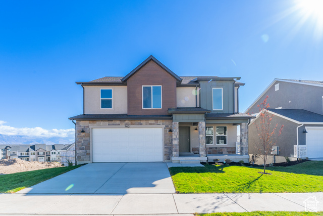 View of front of property featuring a garage and a front yard