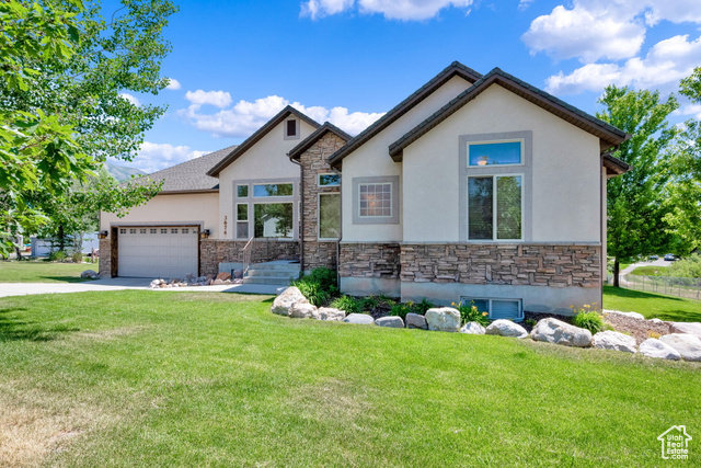 View of front of house featuring a front yard and a garage