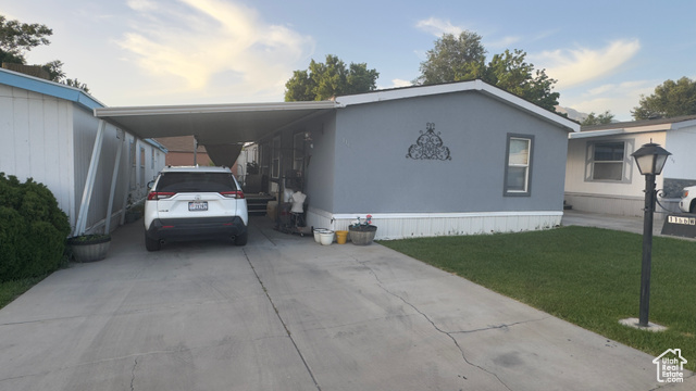 Manufactured / mobile home with a carport and a front lawn