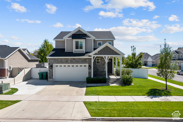 View of front of home with a front lawn and a garage