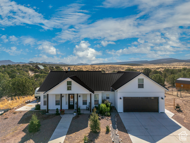 Modern farmhouse style home featuring a garage, a mountain view, and covered porch