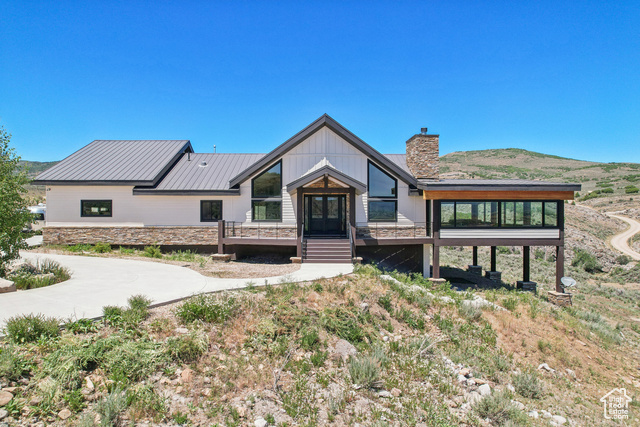 View of front of house with a deck with mountain view