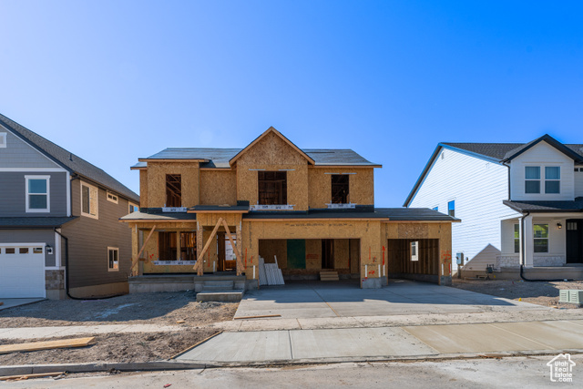 Property in mid-construction featuring a garage and a porch