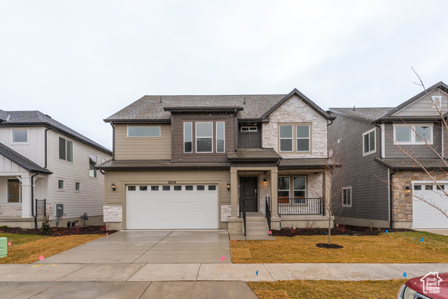 View of front of property featuring a front lawn and a garage