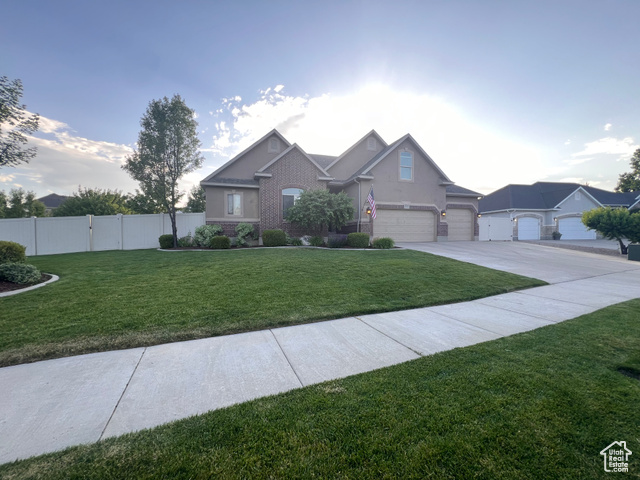 View of front facade featuring a garage and a front yard