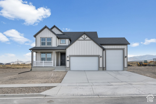 View of front of property with a mountain view, a garage, and a porch