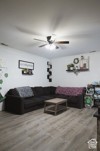 Living room featuring ornamental molding, ceiling fan, and hardwood / wood-style floors