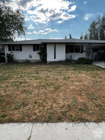 View of front facade featuring a carport and a front yard