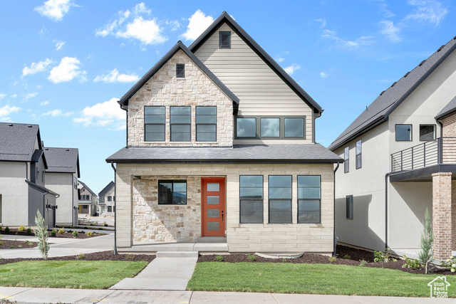 View of front of house featuring a balcony and a front yard