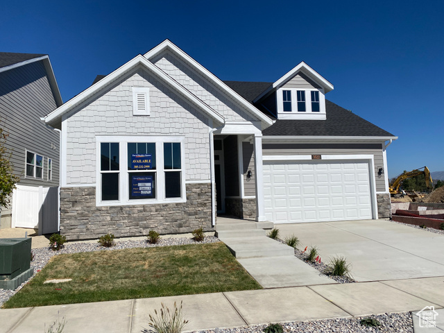 Craftsman-style home featuring a front yard and central air condition unit