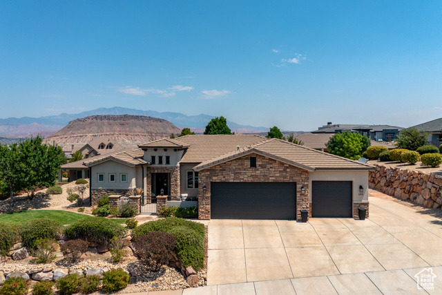 View of front of property with a mountain view and a garage