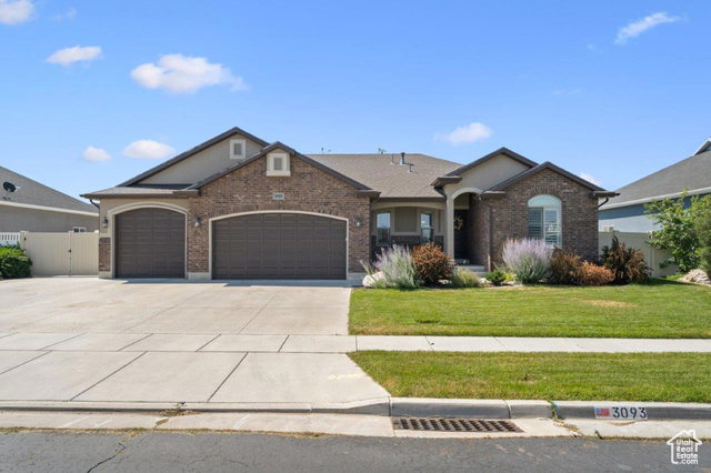 Ranch-style home featuring a garage and a front lawn