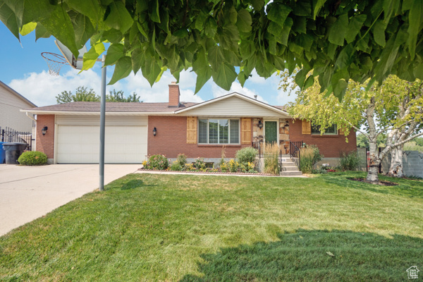 View of front facade featuring a garage and a front yard